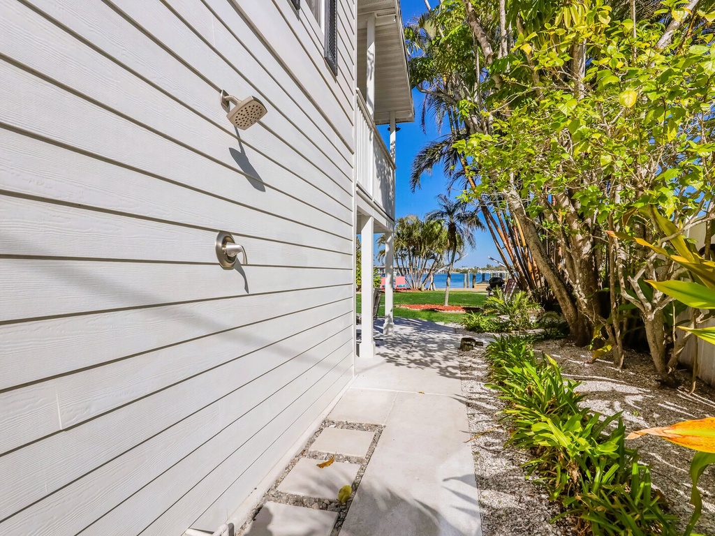 Rinse off after your beach day at your private outdoor shower, surrounded by tropical plants with glimpses of turquoise waters beyond.