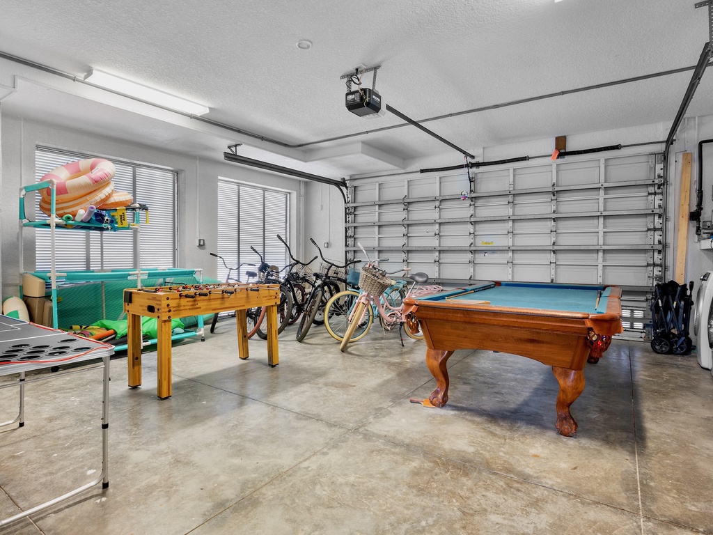 Garage with pool table, foosball, bikes, and laundry