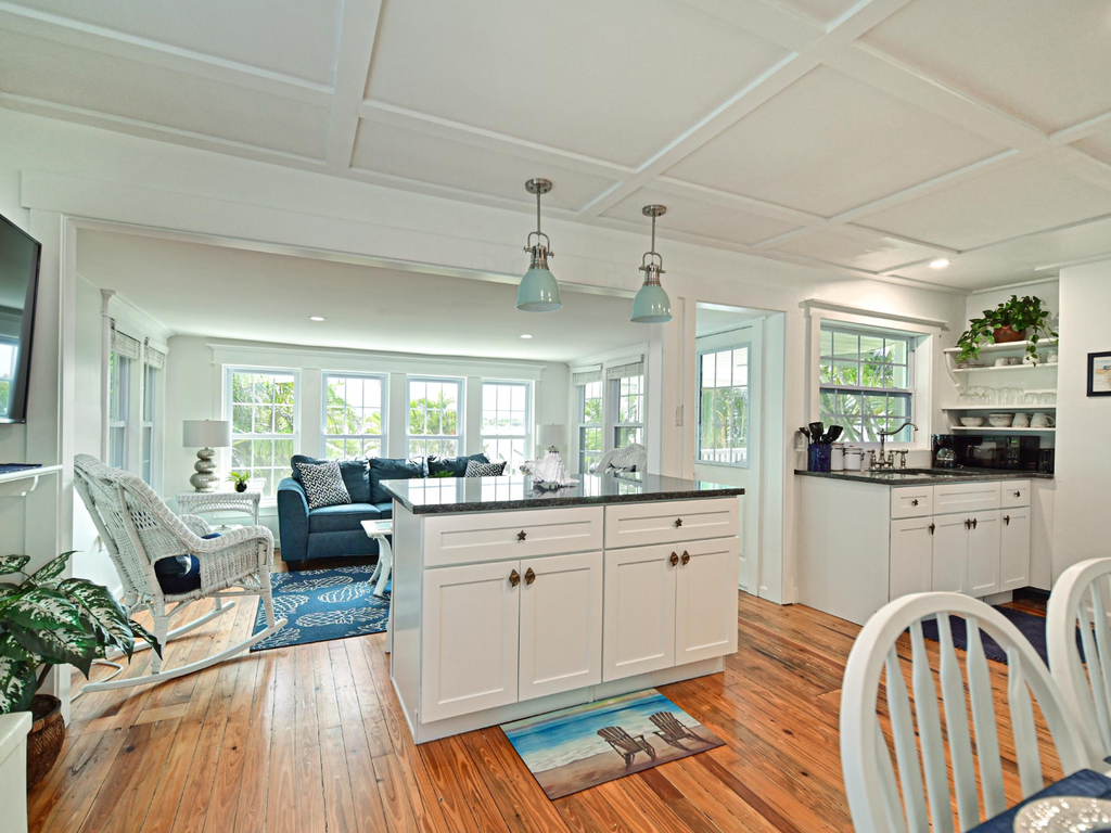 Gather in this bright, open kitchen where gleaming countertops and modern appliances make meal prep a joy, while the adjacent living space invites relaxation.