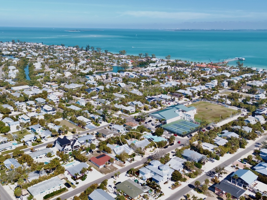 Aerial view of a charming coastal community with pristine turquoise waters and sandy beaches nearby.