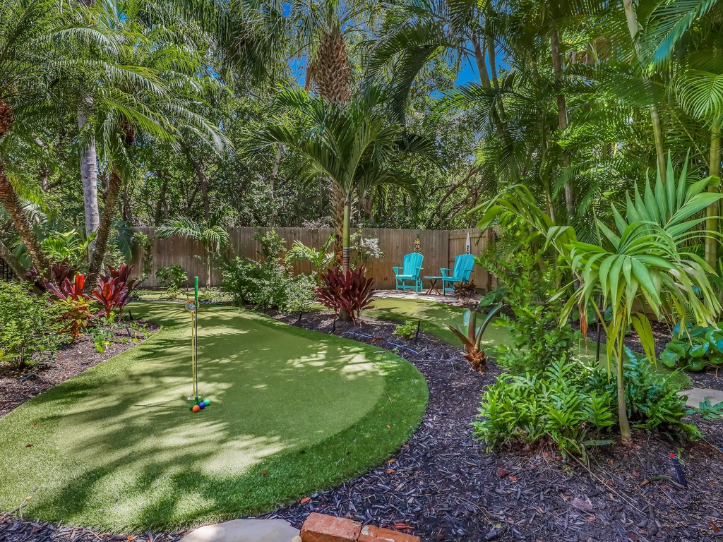 Step into your private tropical oasis with a putting green surrounded by lush palms and vibrant plants—perfect for morning coffee or evening relaxation.