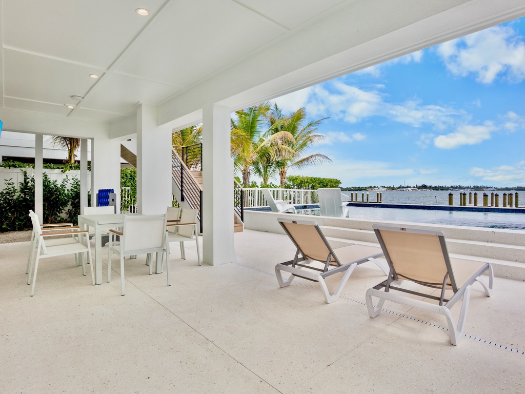 Waterfront home with loungers and dining area