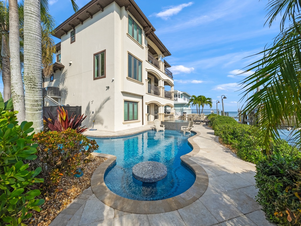 Pristine pool, tropical landscaping, and stunning ocean access