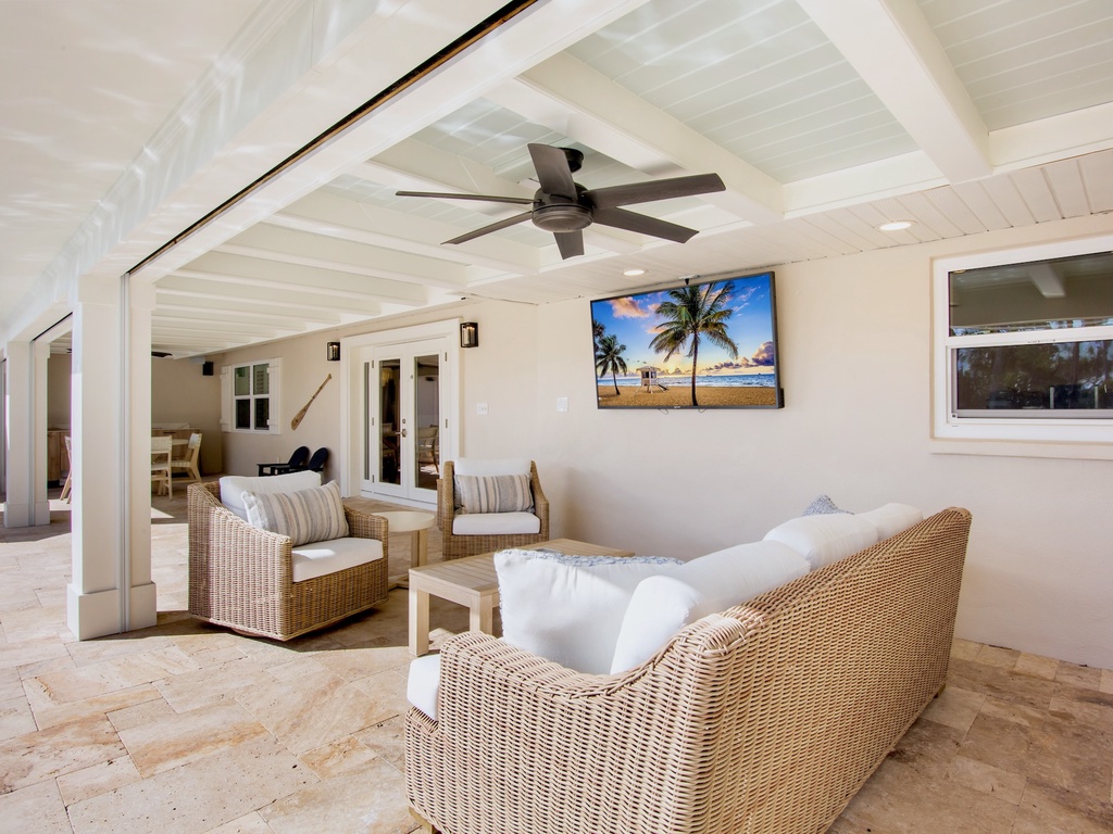 Private covered patio with plush seating and TV