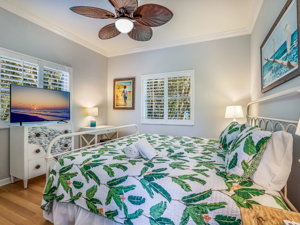 Drift off peacefully in your tropical-themed bedroom, complete with botanical bedding and a ceiling fan for ultimate comfort.