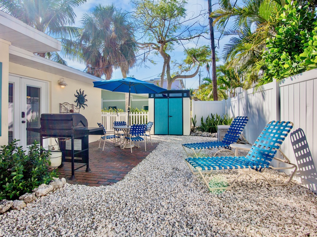 Your private tropical oasis awaits with comfortable lounge chairs, BBQ grill, and lush palm trees creating the perfect outdoor retreat.