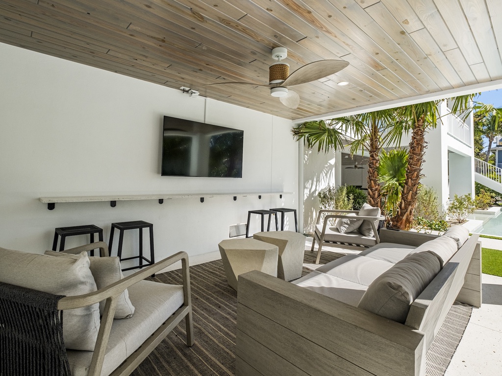 Private covered patio with furniture and TV