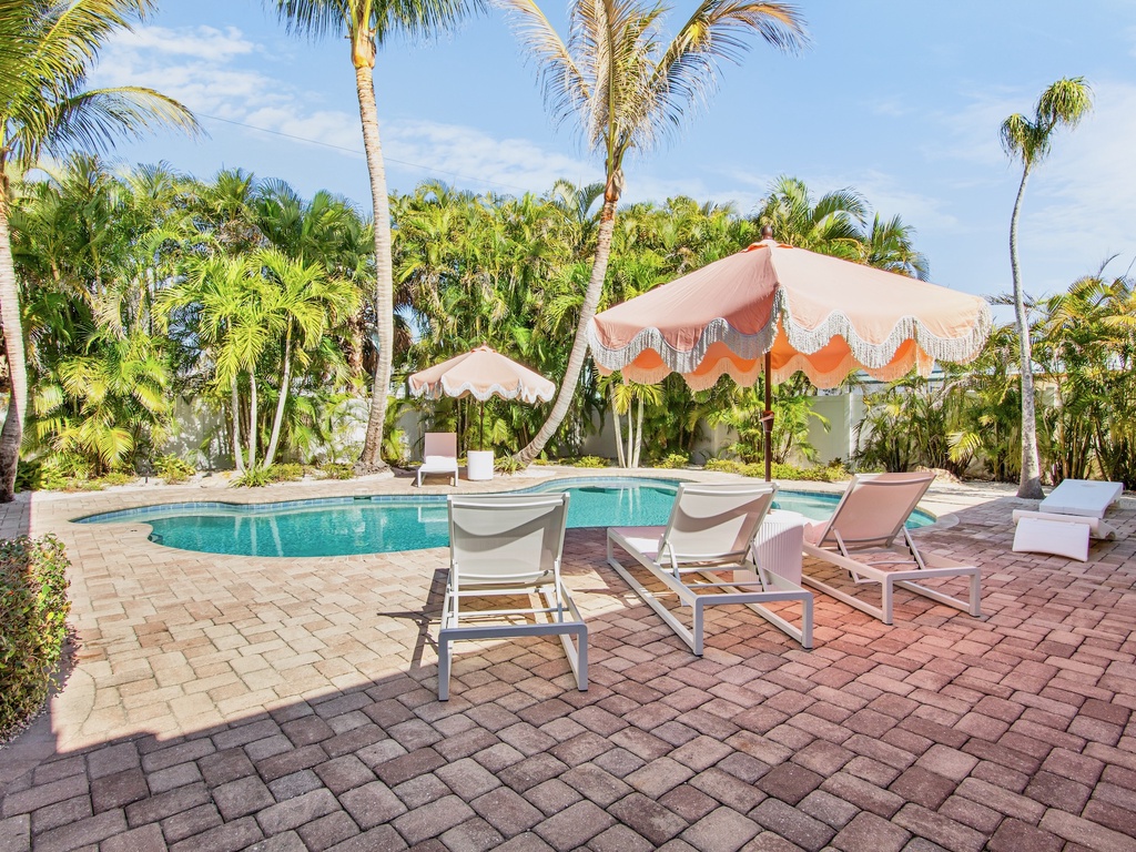 Beautiful pool area with tropical palm trees and umbrellas
