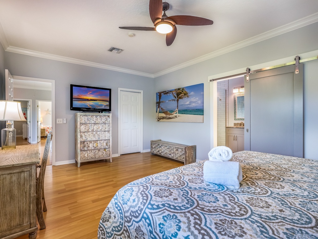 Unwind in your stylish master bedroom with coastal artwork, plush linens, and a private ensuite featuring modern barn doors.