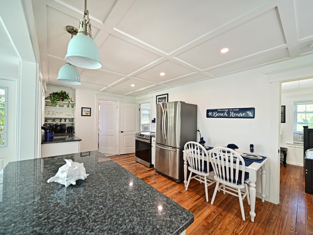 Your bright coastal kitchen awaits with granite countertops, stainless appliances, and charming dining nook perfect for morning coffee.