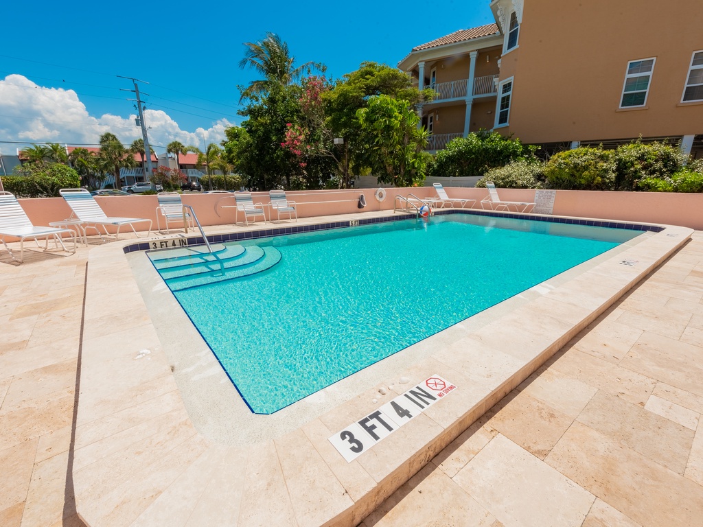 Community pool with sun loungers