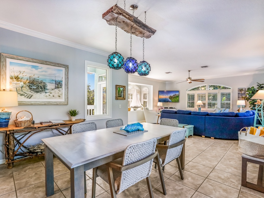 Gather around this spacious dining table while coastal blues and pendant lighting create your perfect family meal atmosphere.