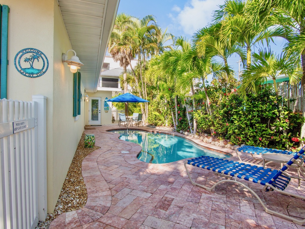 Dive into your own private oasis with a sparkling pool surrounded by lush tropical landscaping and comfortable lounge chairs for the perfect Florida getaway.