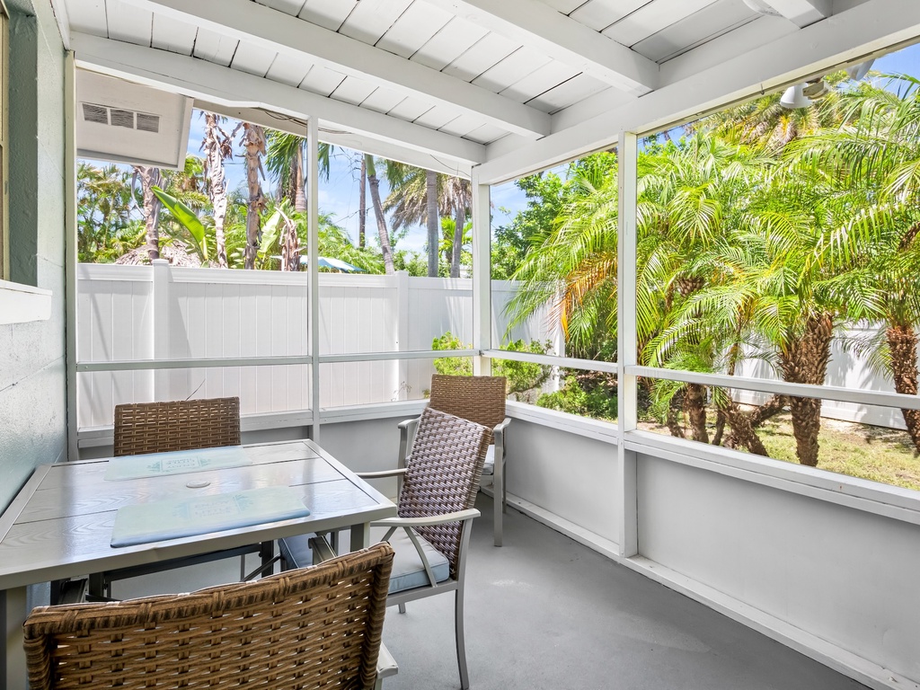 Screened-in lanai with outdoor dining table.