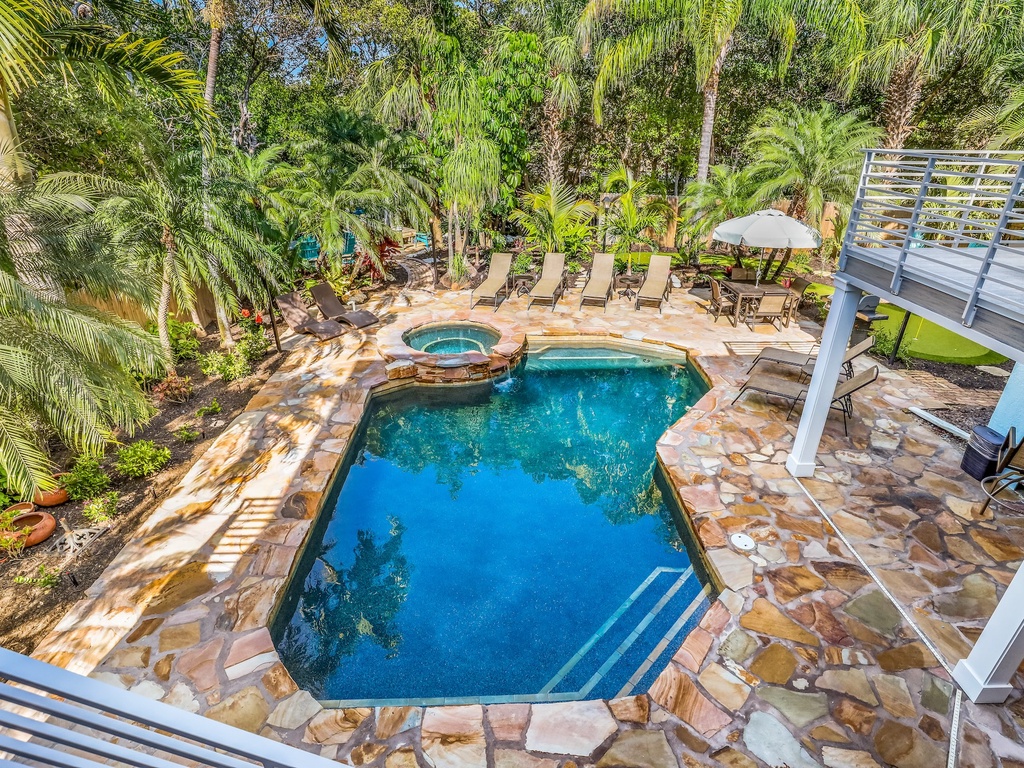 Dive into your private tropical oasis with crystal-clear pool and spa surrounded by lush palms and natural stone decking.