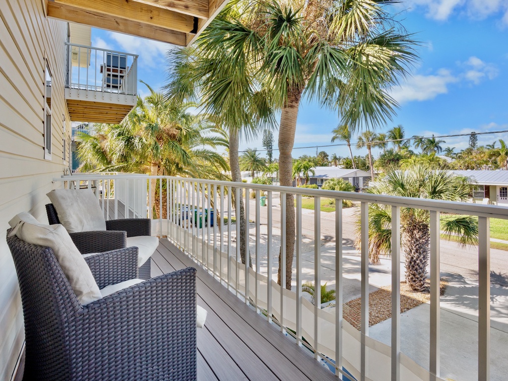 Your private balcony offers comfortable seating and tropical palm views, perfect for morning coffee or sunset relaxation.