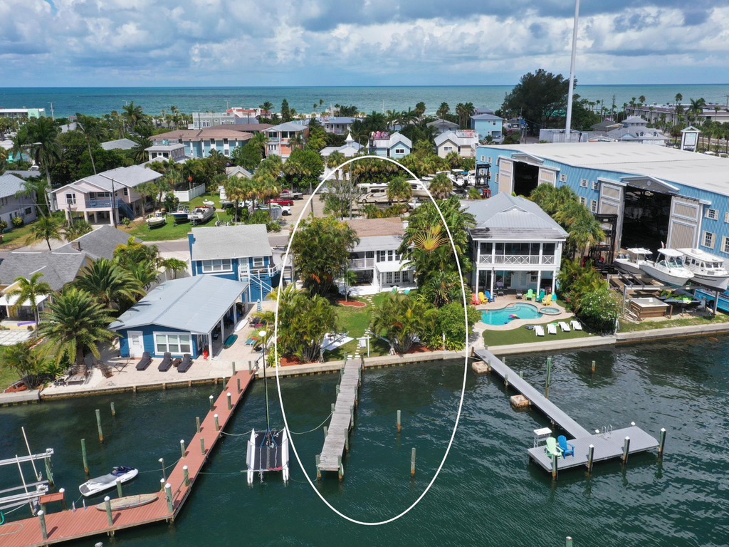 Waterfront property with private dock and pool situated on calm turquoise waters in charming coastal neighborhood.