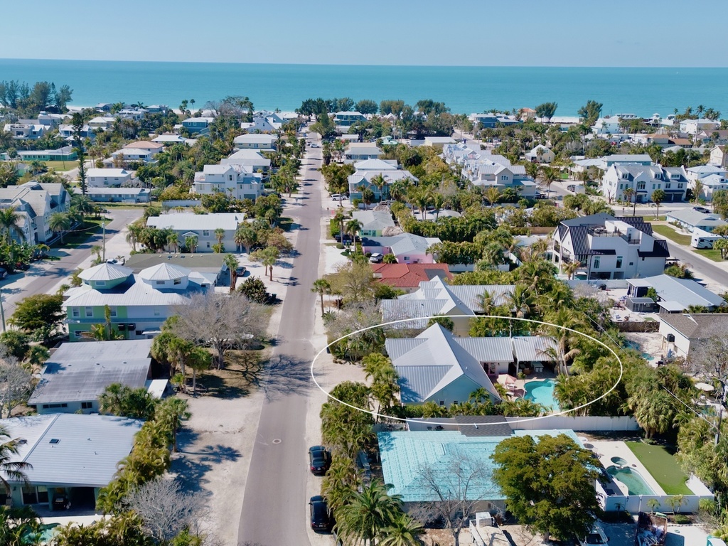 Coastal neighborhood with tropical homes and swimming pools near pristine beachfront, offering a serene island setting for your getaway.