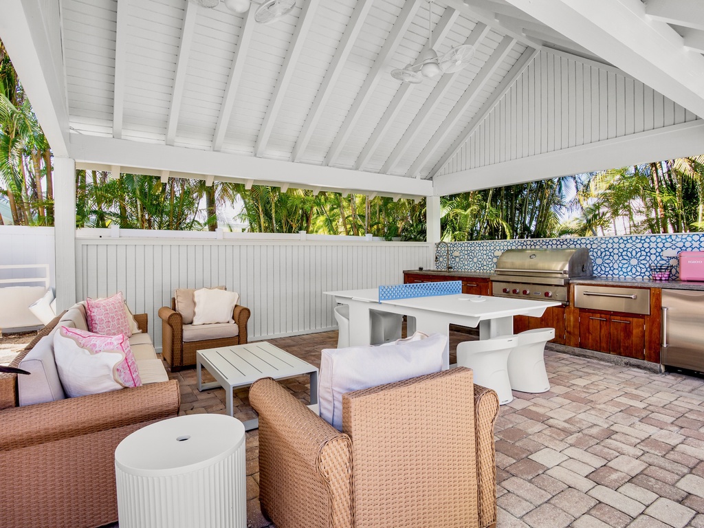 Covered outdoor lounge, grill, and ping pong table to challenge family and friends
