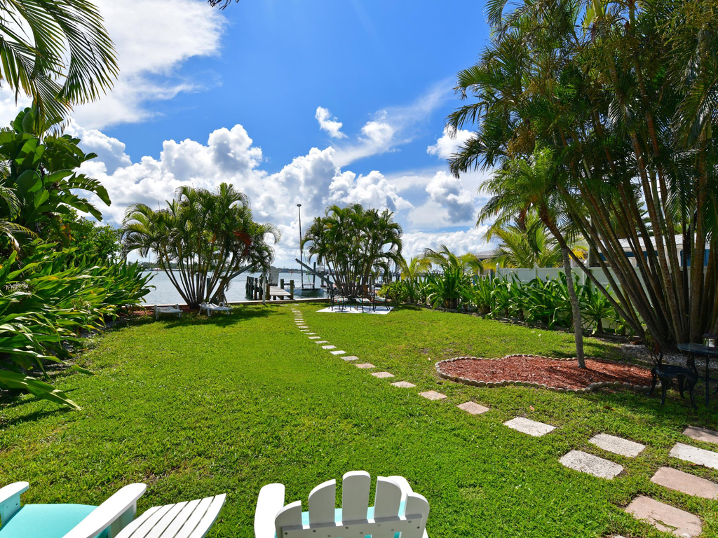 Tropical paradise awaits with lush gardens, waterfront dock, and perfect spots to soak up the sunshine.