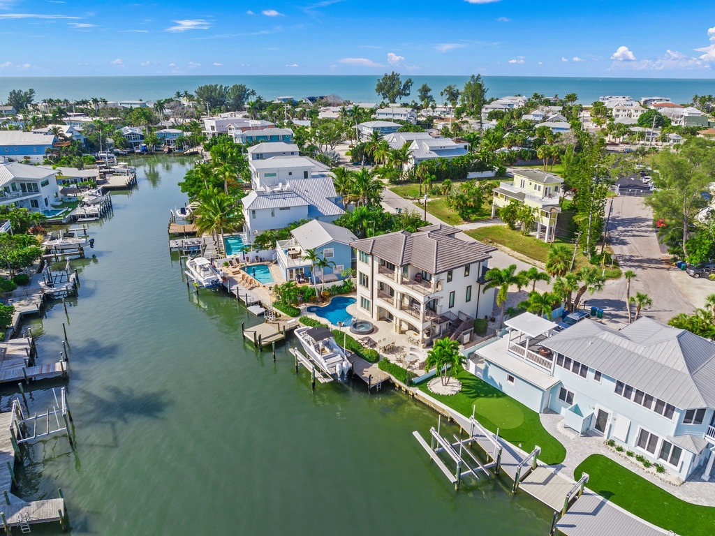 Aerial view of waterfront home, private docks, and swimming pool