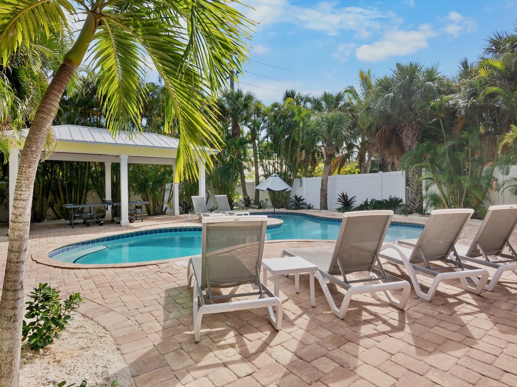Private tropical oasis surrounded by lounge chairs