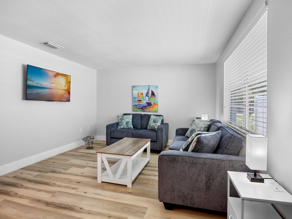 Bright & comfortable living room with plenty of seating to relax after a beach day.