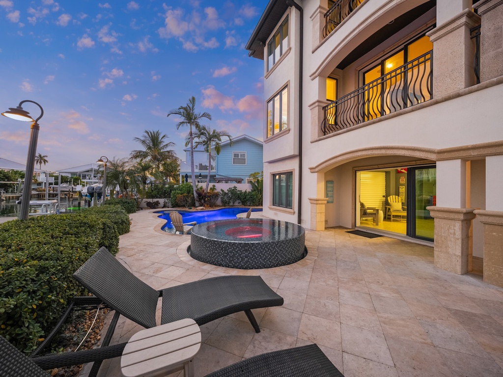 Private pool and hot tub on spacious patio, perfect for sunset relaxation.