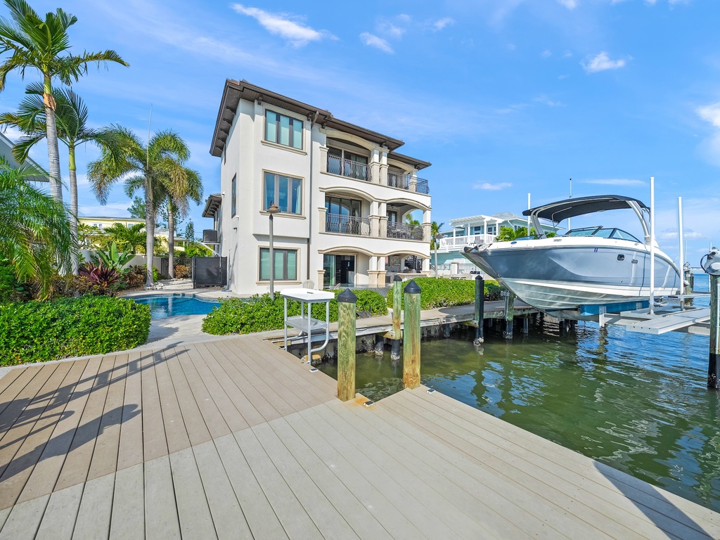 Private dock and boat access, surrounded by tropical palms and sparkling pool.