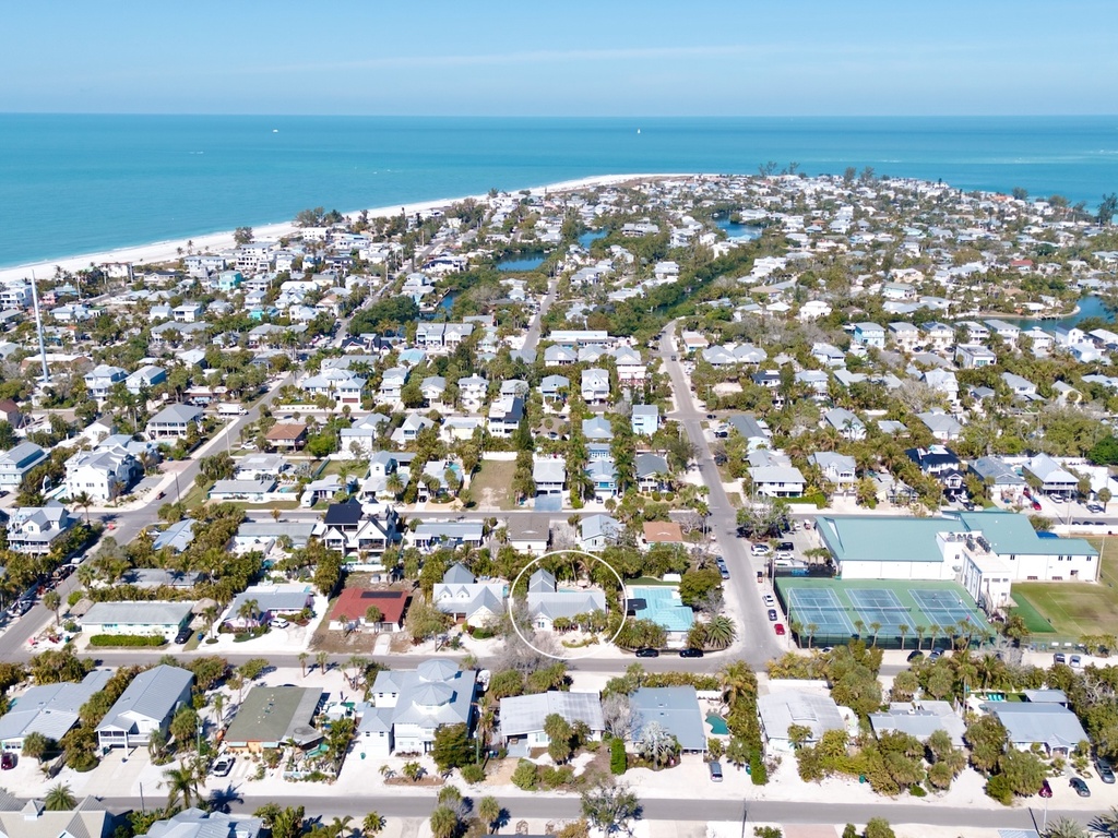 Stunning aerial view of a coastal community with pristine beaches and turquoise waters stretching to the horizon.
