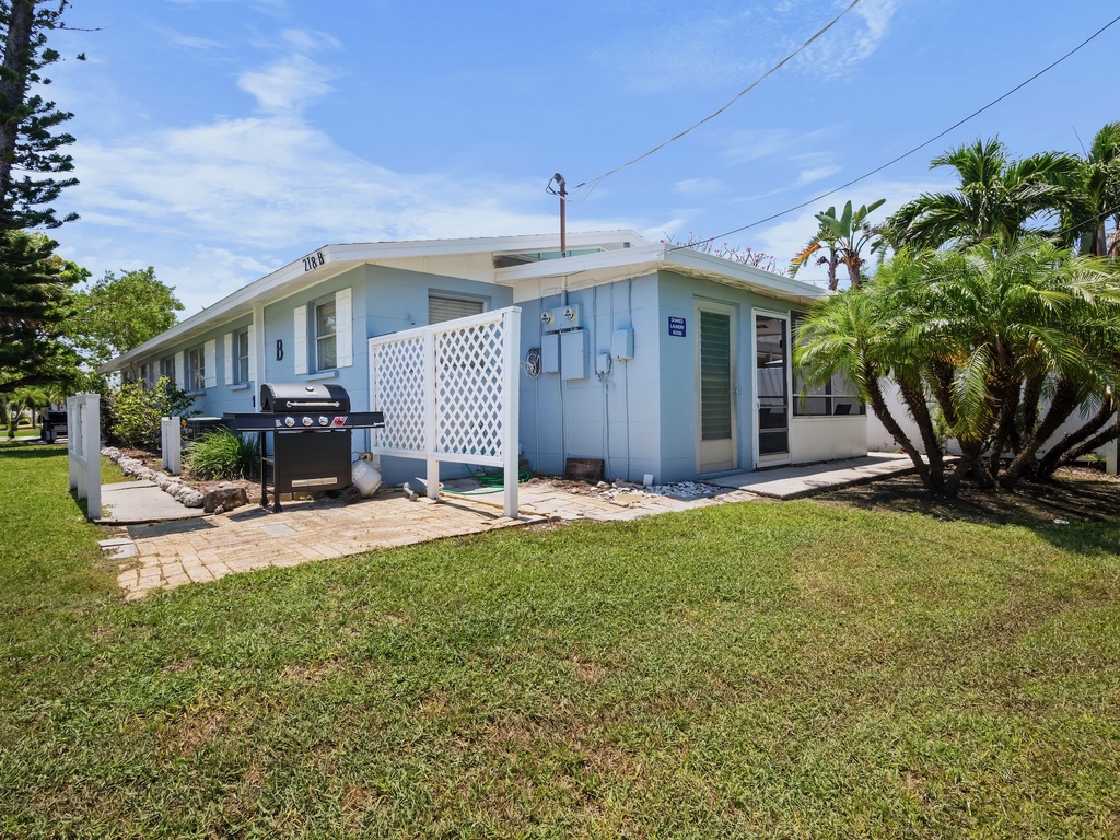 Exterior view of the property with outdoor grill area.