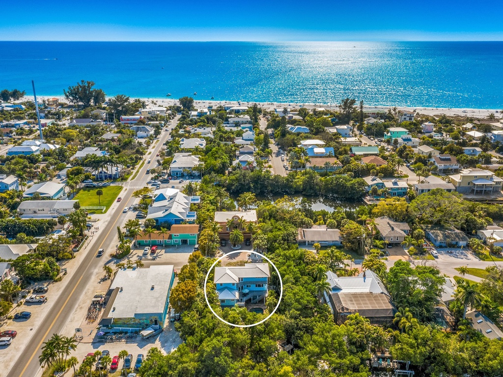 Charming beach community with pristine coastline and tropical trees, just steps from sparkling turquoise waters and sandy shores.