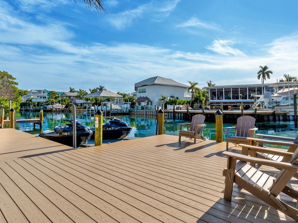 Private waterfront deck with Adirondack chairs
