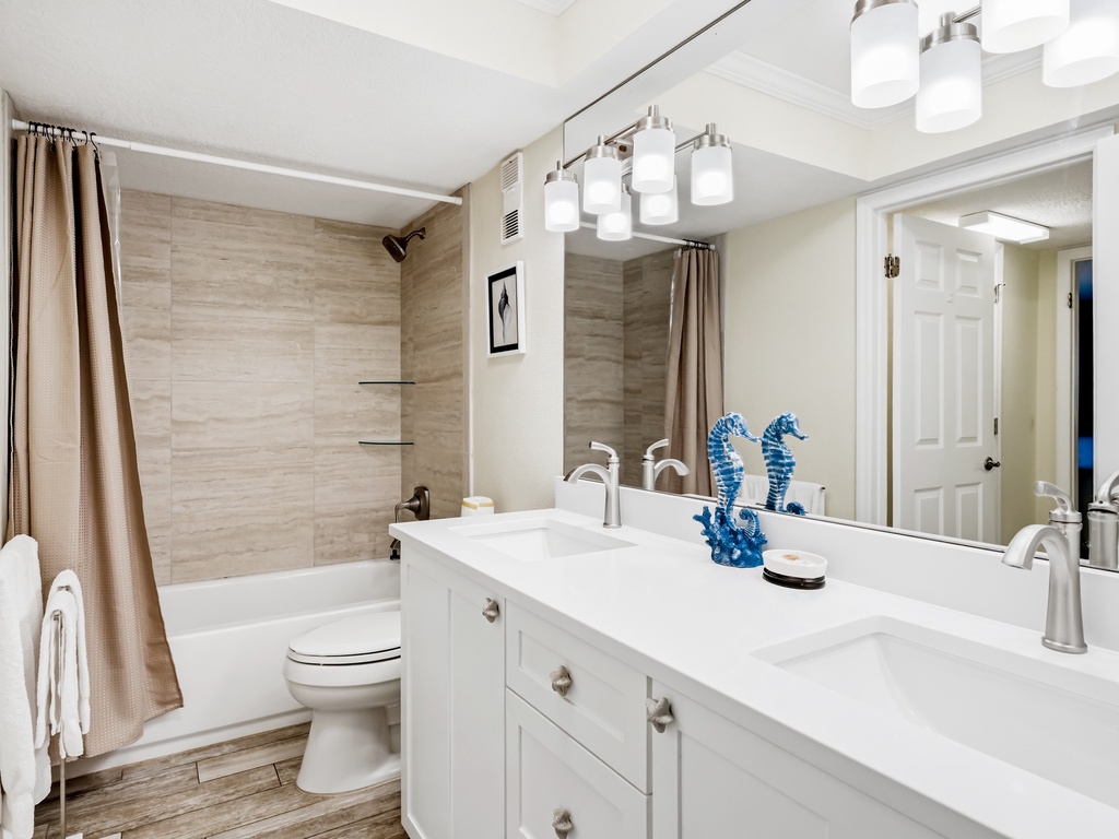 Unwind in your spa-inspired bathroom featuring a soaking tub, dual vanity, and elegant coastal touches that invite relaxation.