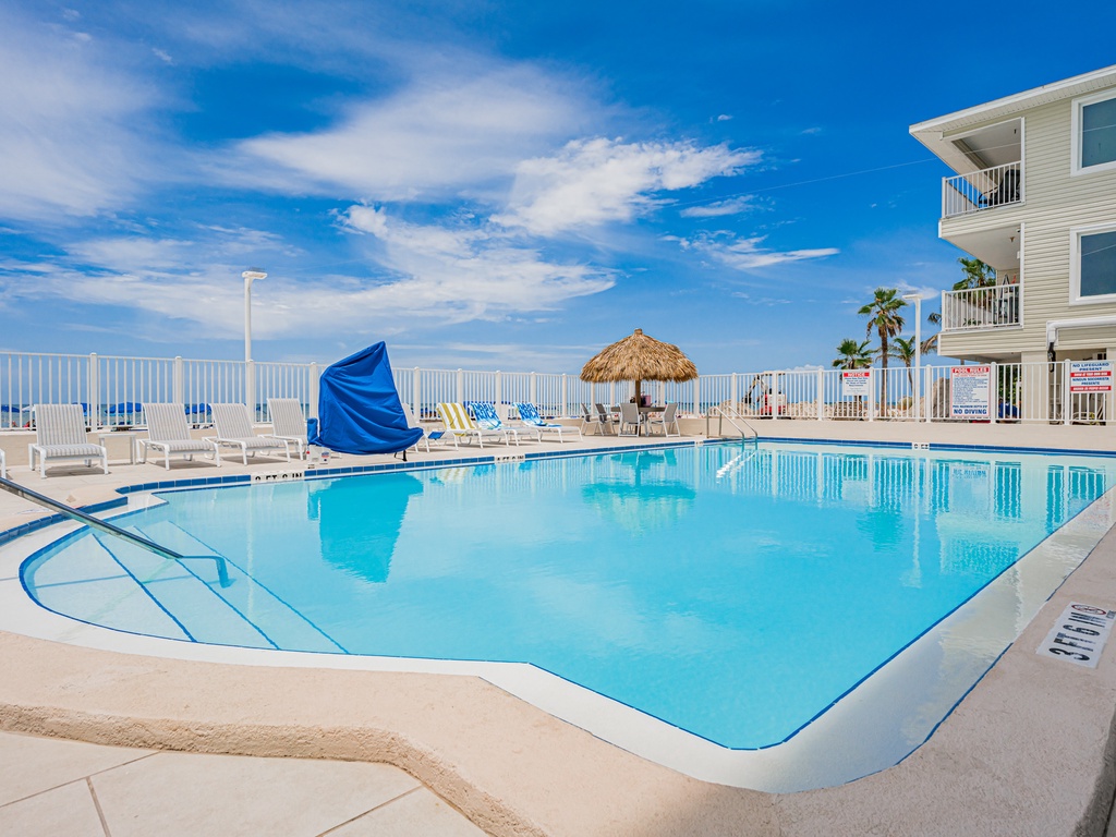 Dive into crystal-clear waters surrounded by tropical charm. This sparkling pool beckons you to unwind under blue skies.
