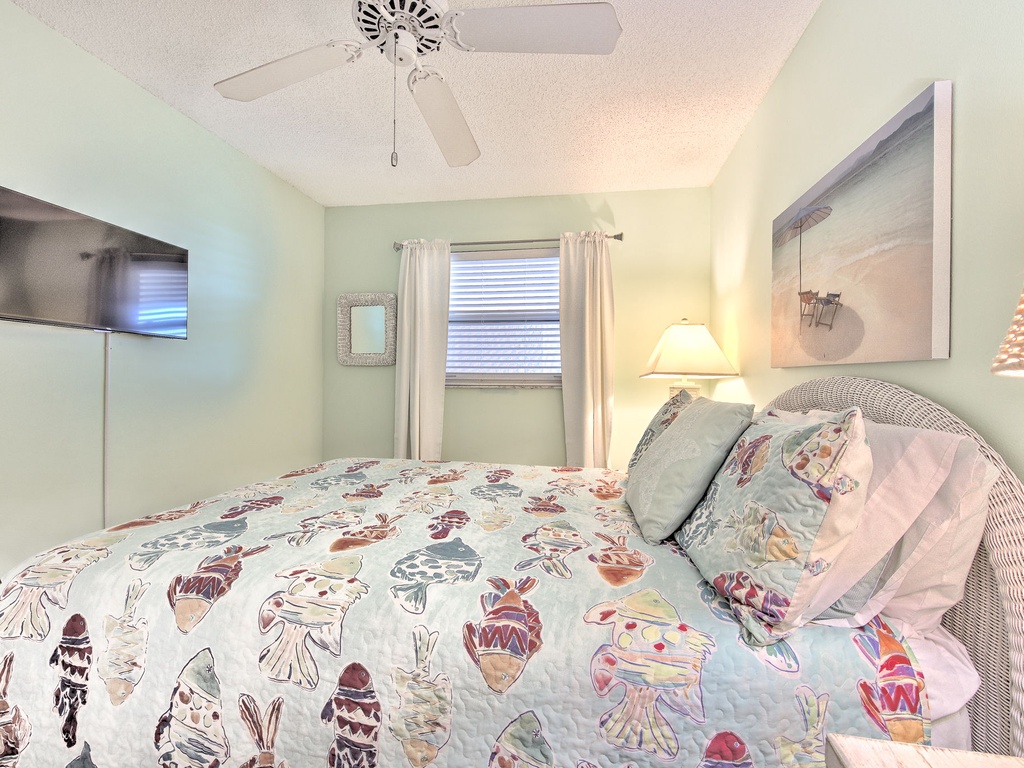 Drift into dreams in your coastal bedroom, where playful linens and gentle ceiling fan breezes create the perfect retreat after beach adventures.