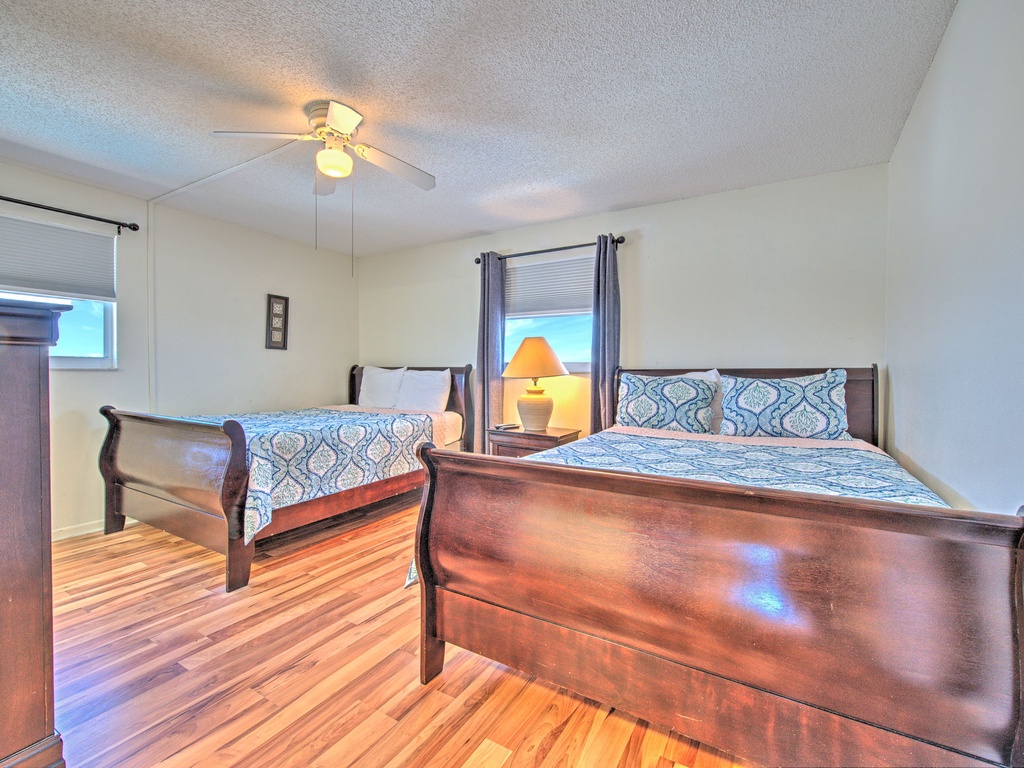 Relax in your spacious bedroom with two comfortable beds, warm hardwood floors, and gentle ceiling fan keeping you cool.