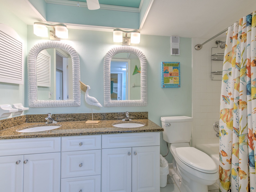 Step into your coastal-themed bathroom with dual vanities, granite counters, and cheerful tropical accents that make your morning routine a vacation experience.