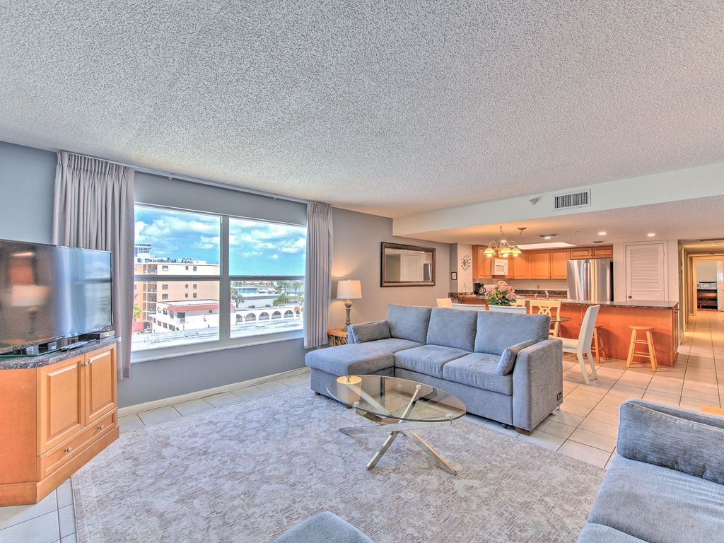 Unwind in your spacious living room with plush seating, city views, and open-concept design flowing into a modern kitchen.