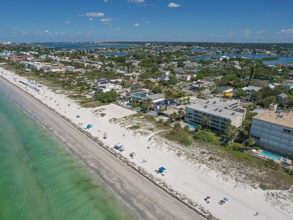 Stunning beachfront location with pristine white sand and crystal-clear turquoise waters stretching along the coast.