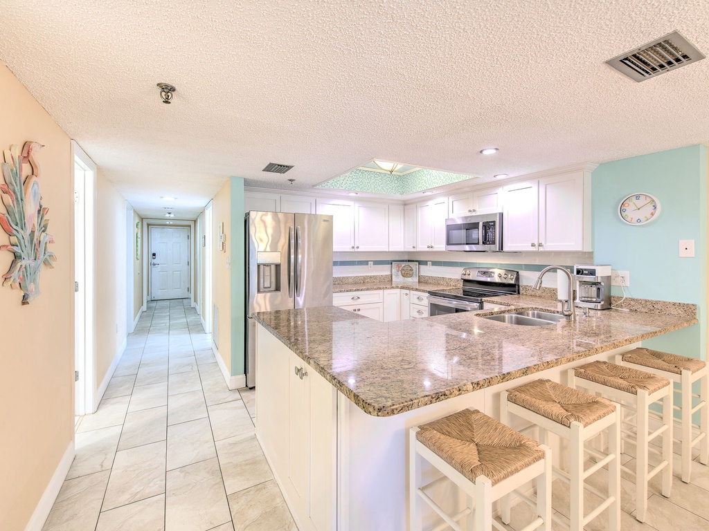 Your spacious kitchen features granite countertops, stainless steel appliances, and a breakfast bar perfect for morning coffee or casual meals.