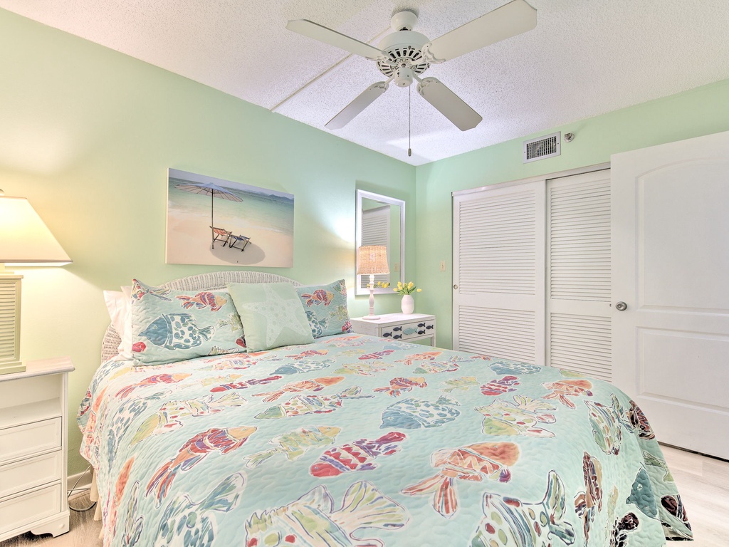 Rest in your coastal-inspired bedroom with sea-themed linens, gentle ceiling fan breeze, and peaceful seafoam walls creating the perfect ocean retreat.
