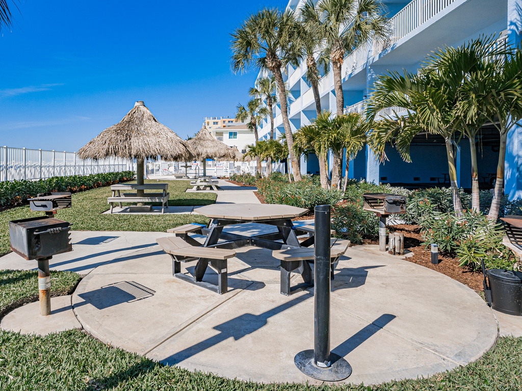 Tropical paradise awaits with tiki huts, palm trees, and BBQ stations creating your perfect outdoor dining experience.