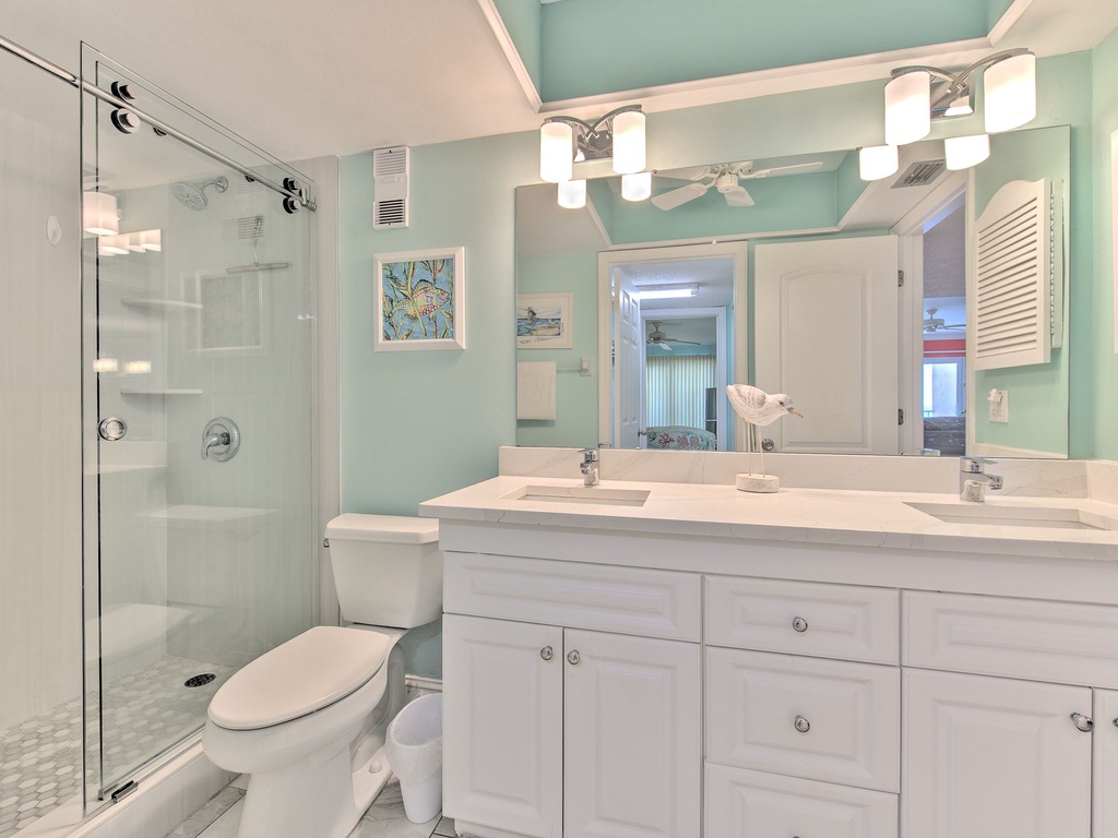 Refresh in your bright, coastal-inspired bathroom with modern double vanity, spacious glass shower, and soothing seafoam walls.