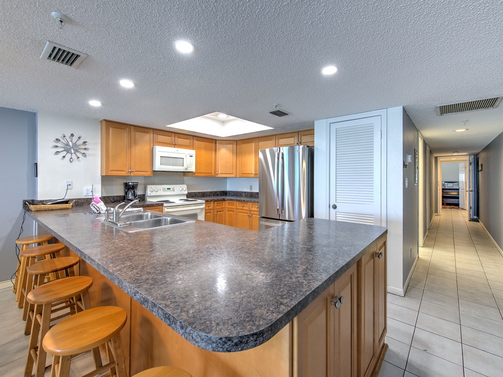 Prepare your favorite meals in this spacious, well-equipped kitchen featuring granite countertops, stainless steel appliances, and a convenient breakfast bar perfect for morning coffee.