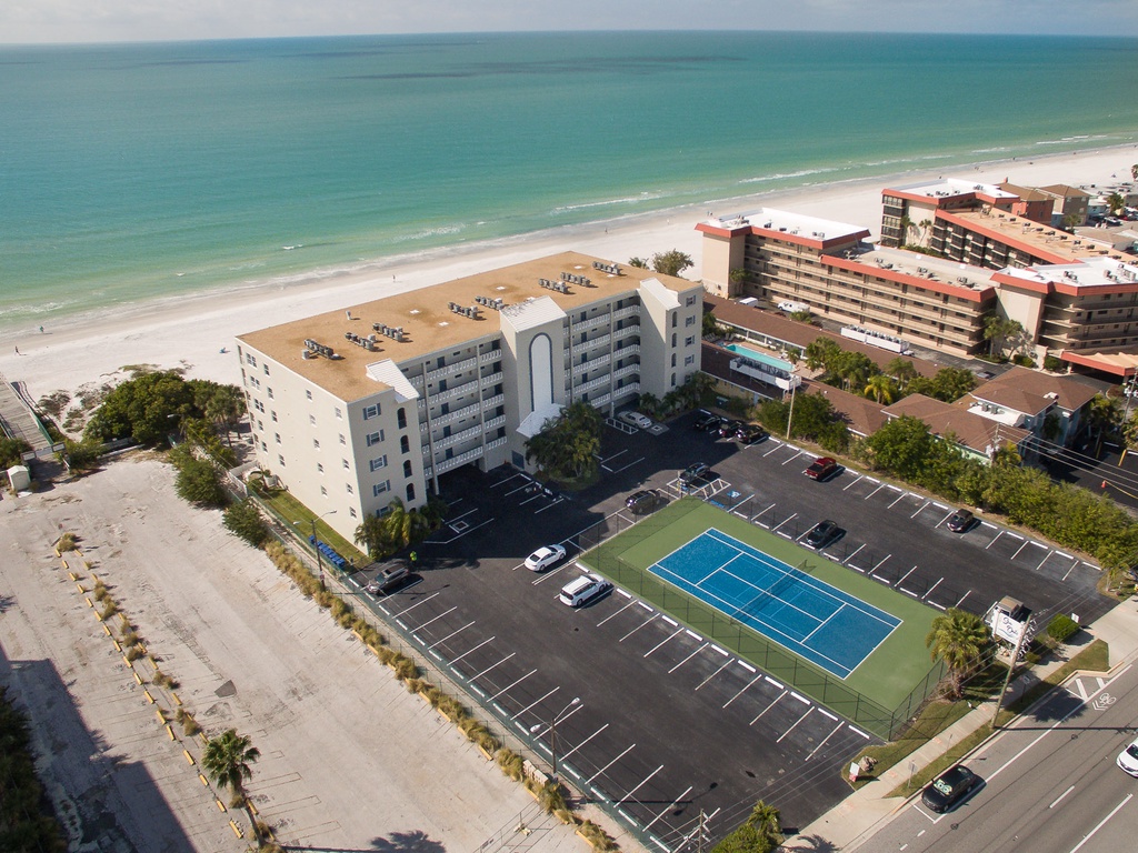 Beachfront property with tennis court and parking, steps from pristine white sand beaches and turquoise Gulf waters.
