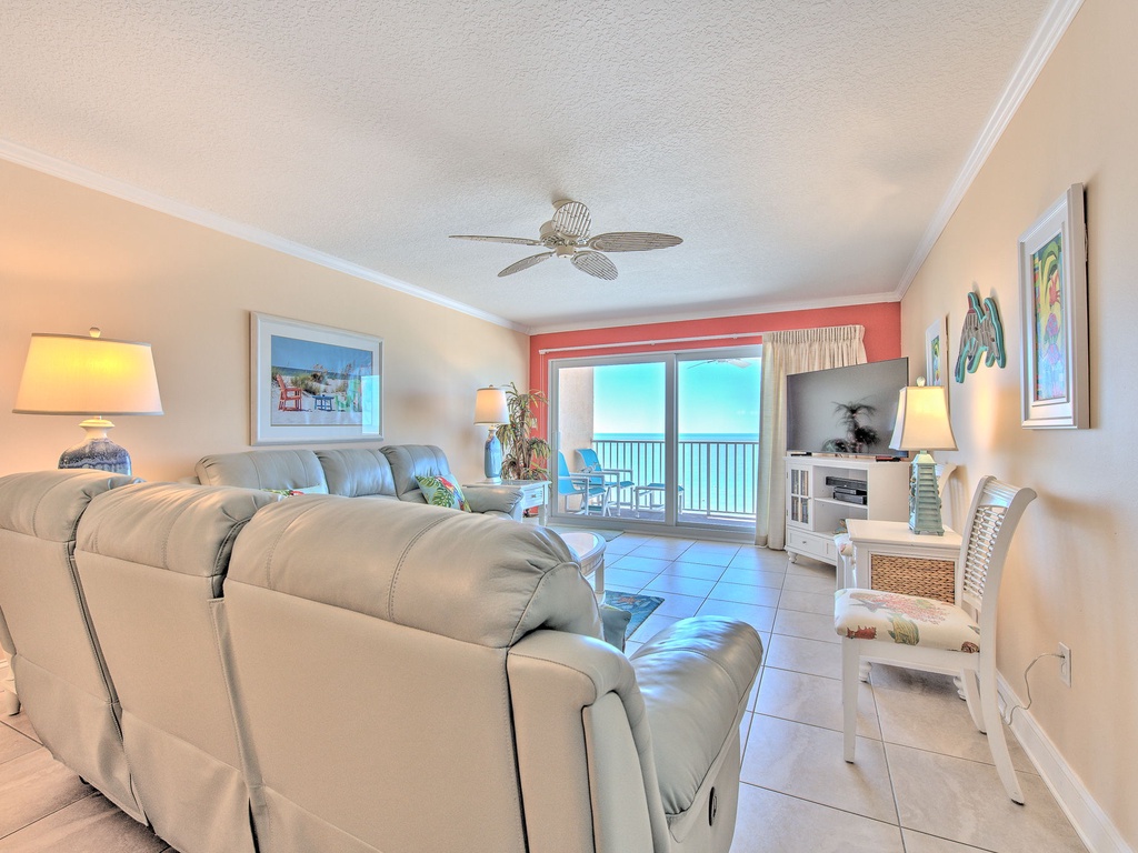 Your oceanfront living room offers stunning sea views through floor-to-ceiling windows, with comfortable seating and gentle ceiling fan breezes for ultimate relaxation.
