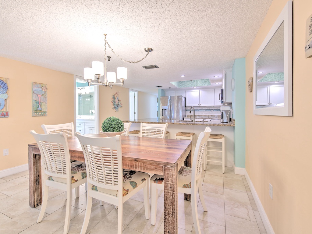 Gather around your spacious dining table where beach-themed artwork and coastal colors create the perfect setting for memorable meals together.