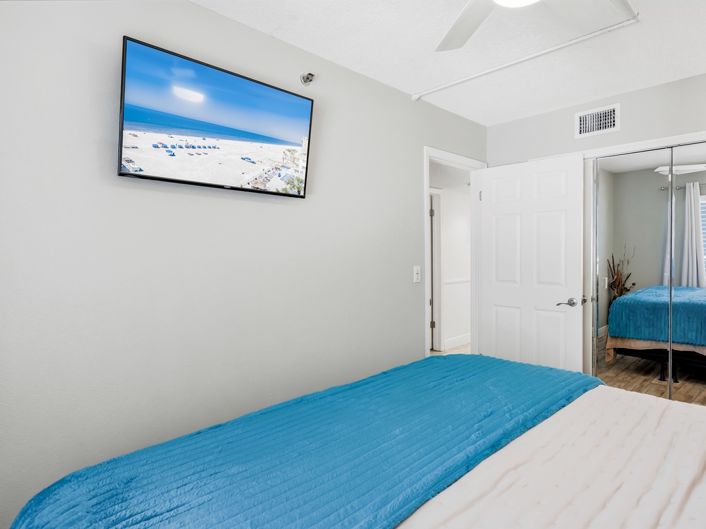 Relax in your bright bedroom with coastal wall art, premium bedding, and mirrored wardrobe doors that create an airy, spacious feel.