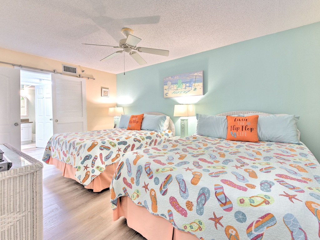 Drift off to peaceful sleep in your coastal-themed bedroom with twin beds dressed in cheerful flip-flop bedding and gentle turquoise walls.